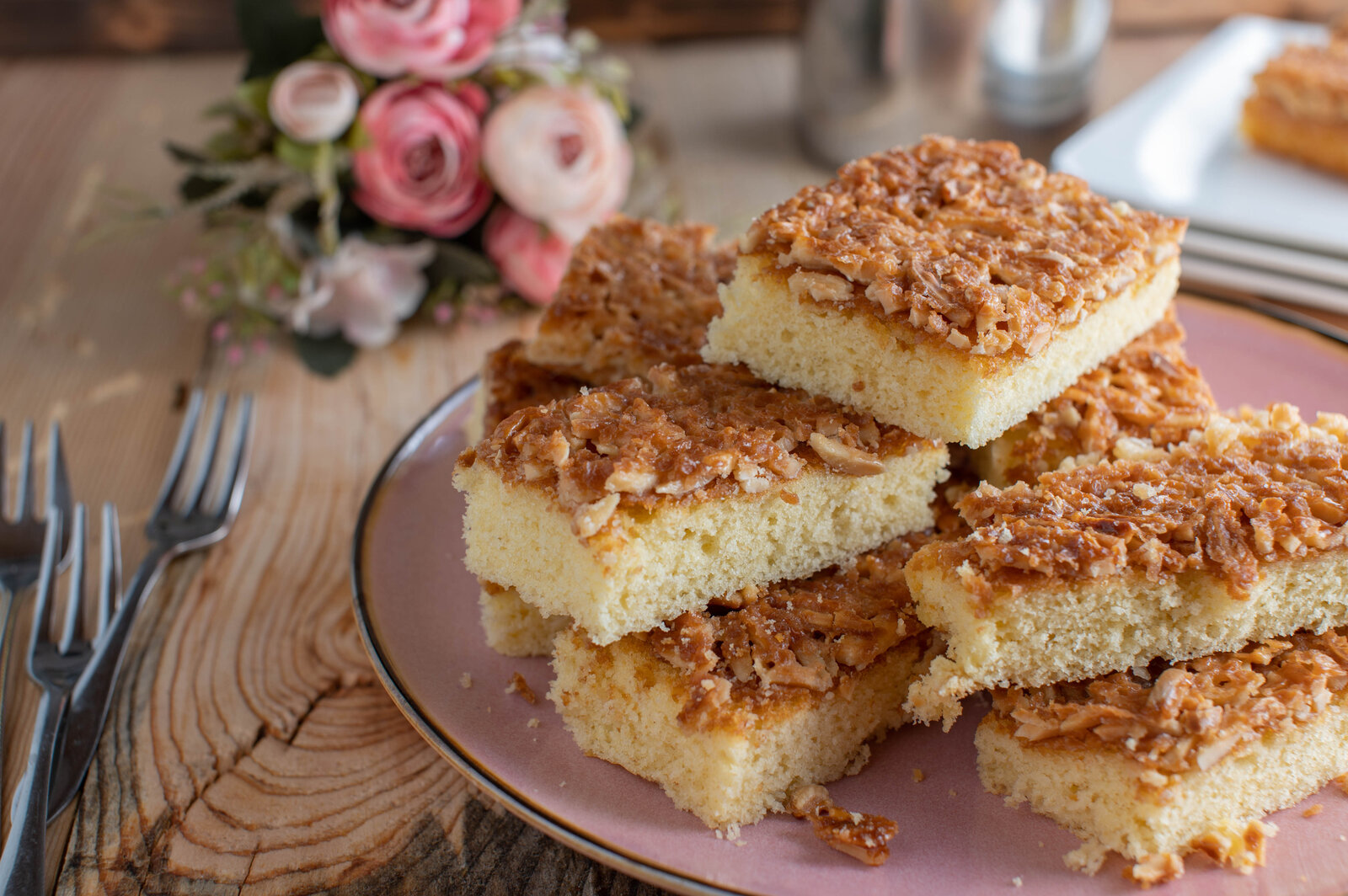 Stücke von Buttermilch-Blechkuchen angerichtet übereinander auf einem weißen Teller. | © Getty Images / Angelika Heine
