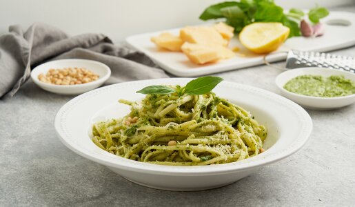 Aufgedrehte hausgemachte Pasta auf weißem Pasta-Teller, in grünem Pesto. | © Getty Images / Natalia Gdovskaia