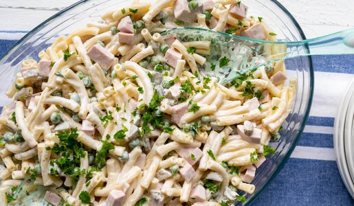 Nudelsalat mit Fleischwurst und Erbsen ohne Mayo aber mit Joghurt in einer Glasschüssel angerichtet. | © Getty Images / Angelika Heine