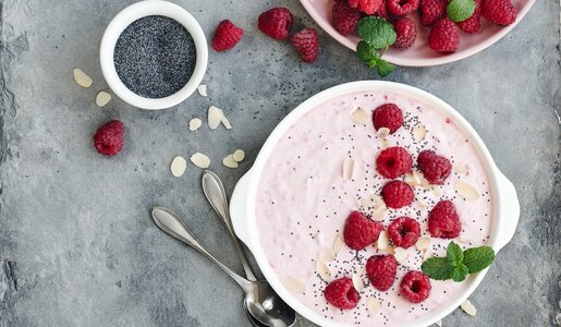 Schüssel mit Himbeerjoghurt und frischen Himbeeren sowie einem frische Minzeblatt. | © Getty Images / Nataliia Sirobaba