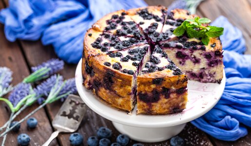 Angeschnittener Joghurtkuchen mit Blaubeeren daneben frischer Lavendel. | © Getty Images / YelenaYemchuk