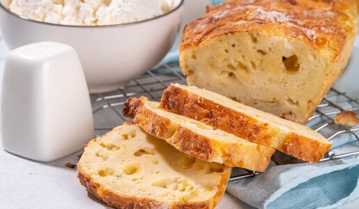 Angeschnittenes luftiges Hüttenkäse-Brot auf einem Abkühlgitter. | © Adobe Stock / ricka_kinamoto