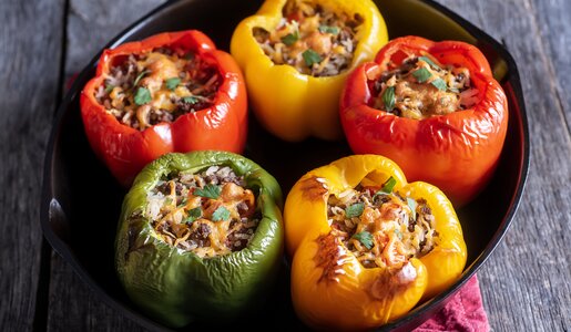 Fünf gemischte gefüllte Paprika in einer Auflaufform mit Hackfleisch gefüllt. | © Getty Images / rudisill
