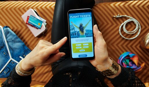 Frau bucht Flug über Handy | © gettyimages / CentralITAlliance