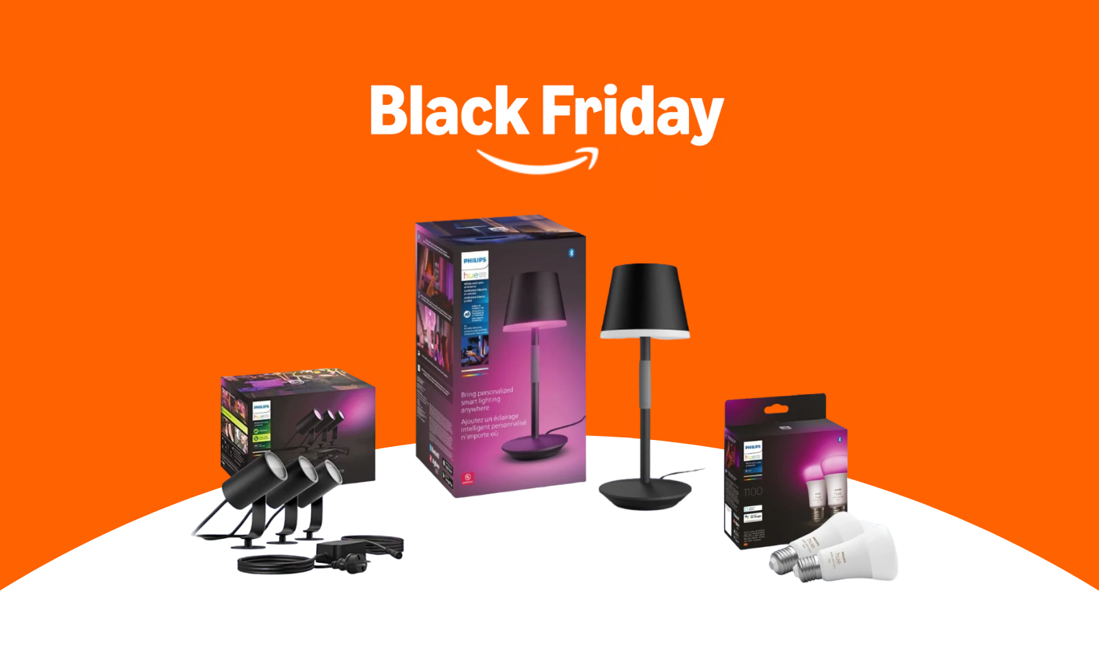 Black Friday-Angebot für Philips Hue mit drei LED-Spots, einer Tischlampe und zwei Glühbirnen auf orange-weißem Hintergrund. | © Amazon/Philips