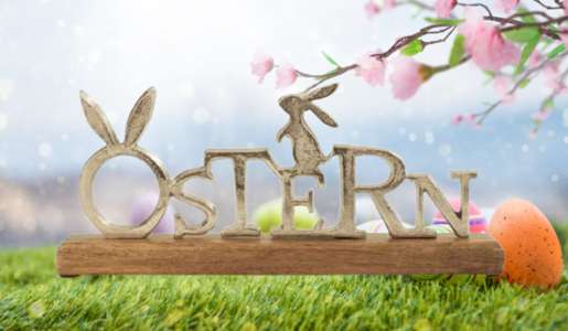Aufsteller mit dem Schriftzug Ostern vor österlichem Hintergrund | © Amazon/Getty/loops7 